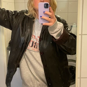 Cool skin jacka  - Säljer denna coola skinnjackan med knappar som är köpt på second hand. Den är i fint skick och är i äkta skinn. På bilderna är det spegeln som är fläckig/smutsig och inte jackan. Jag vet inte riktigt vilken storlek jackan är i med den är stor på mig som brukar ha S/M. Skriv om ni vill ha mer information och köparen står för frakten dock vet jag inte riktigt hur mycket den blir då jag behöver köpa frimärken till en kartong