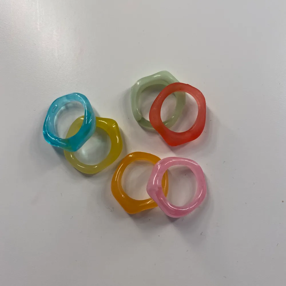 Säljer 6 stycken färgglada ringar som aldrig är använda då de är för stora för mig. . Accessoarer.