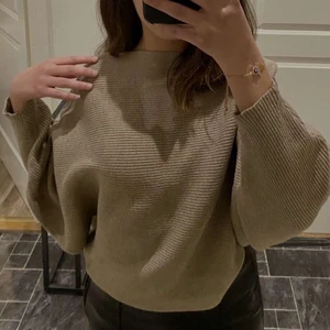 Ribbstickad tröja - Urtjusig beige/tan färgad ribbstickad tröja från Zara i en väldigt smickrande modell. Perfekt nu till vintern för att hålla sig varm! Plagget är i bra skick!