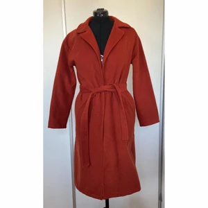 Höstkappa - Lång kappa i en härlig höstfärg med knytning i midjan och fickor. Säljer pga för liten, använd ett fåtal gånger i bra skick. 