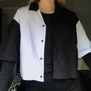 Svartvit skjorta - Jättecool kortärmad skjorta från märket sweet sktbs. Den är i storlek S i herrstorlek och passar snyggt oversized på mig som vanligtvis har storlek S i damstorlek. Den är helt oanvänd med prislappen kvar men värt att poängtera är att jag har klippt den själv så att den slutar lite under byxkanten på mig som är 173 cm lång. Pris kan diskuteras!