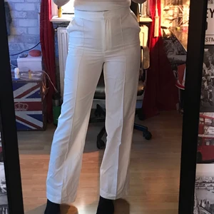 Vita kostymbyxor från nakd - Fina vita kostymbyxor med pressveck fram. De är ifrån nakd x Misslisibell. Storlek 36 men skulle säga att de även passar 34. Jag är ca 173 cm och de går precis ned till fötterna på mig. Pris kan diskuteras! Obs upptäckte idag en liten fläck under ena knät (bild 3), vet inte om den går att få bort men kommer naturligtvis försöka, bara så att man är medveten om det!