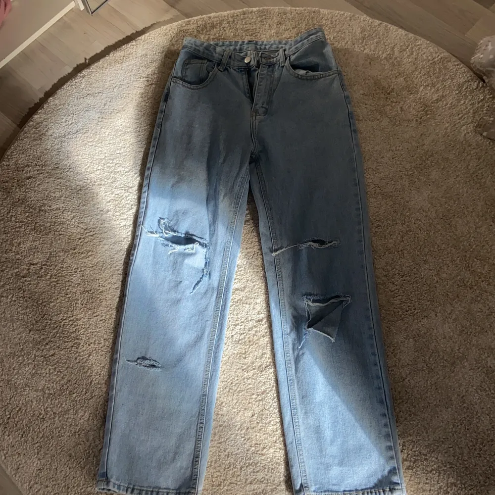 Ett par blåa jeans med hål på knäna, väldigt fin färg och populära byxor!Stl xs/32 men skulle säga att en 34 eller till och med 36 skulle gå 😊 om det är många som är intresserad så startar jag en budgivning.❤️. Jeans & Byxor.
