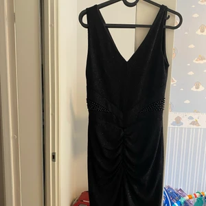 Svart klänning stl S - En svart jätte fin klänning med pärlor. Aldrig använd. Köpt i Makedonien. Storlek S. Frakt betalas av köparen 