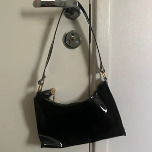 Genomskinlig axelväska - Säljer denna snygga blanka genomskinliga väska. Aldrig använd, nyskick! Guldfärgad kedja, svart blank som är lite genomskinlig. Fråga om de något ni undrar💕💕💘