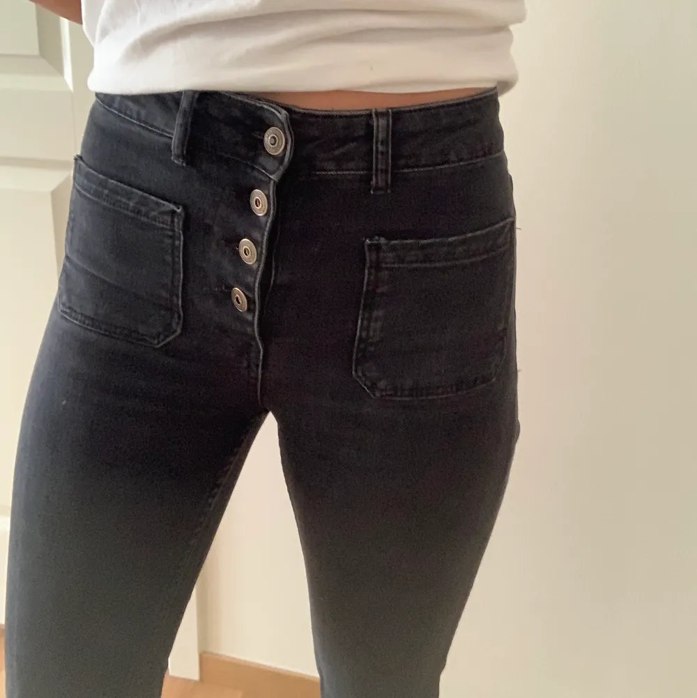 Svarta zara jeans med synliga knappar och fickor på framsidan. . Jeans & Byxor.