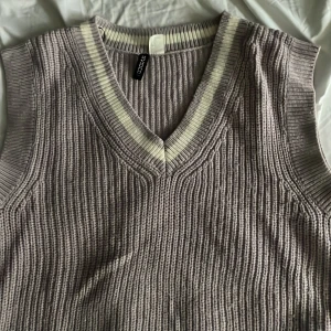 Lila stickad tröja - En fin lila stickad väst. Fin att han en långärmad tröja under eller likadande. I strl S från hm