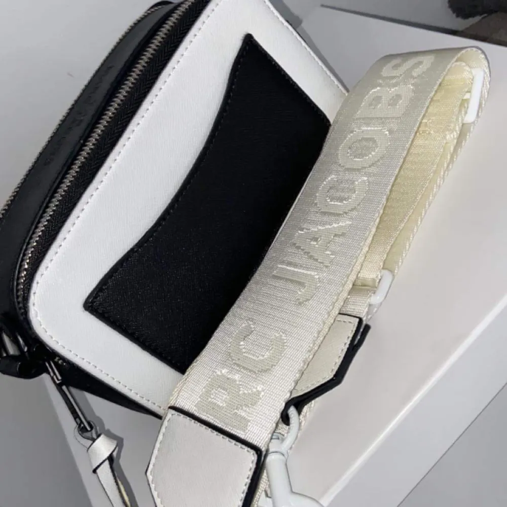 Har denna riktigt snygga Marc Jacobs väska obs ej äkta men i riktigt bra kvalitet ny oanvänd i svart o vit färg med ett brett justerbart band med loggan på . Accessoarer.