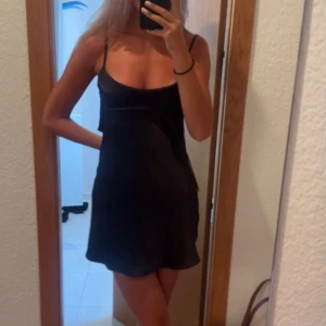 Satinklännig Zara  - Säljer denna populära svarta miniklänning från Zara. Oanvänd, prislappen sitter kvar. Storlek M men funkar för S också. Den går självklart att knäppa där bak (det var bara jag som inte orkade göra det när bilden togs 😅) 