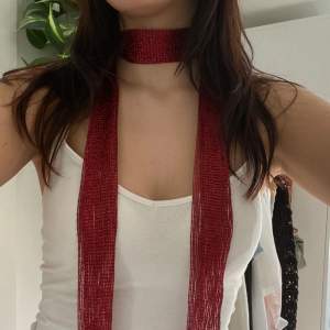En smal halsduk i röd färg 
