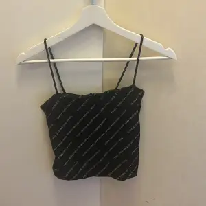 Ett linne från Gina Tricot med text på, Den är kort i modellen och smala band
