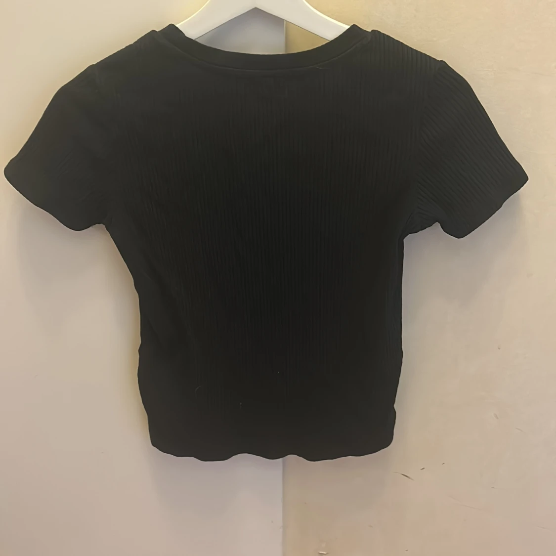 En svart kortärmad tröja men en Knut  - 90