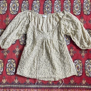 Blus - Gul/beige blommig blus med både knytning fram och bak! I storlek 40 men mer som en 38