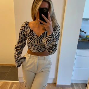 Zebra mönstrad top, knytning rygg - ”Zebra” mönstrad top, ljusbeige/svart. Sparsamt använd. Knytning i ryggen.