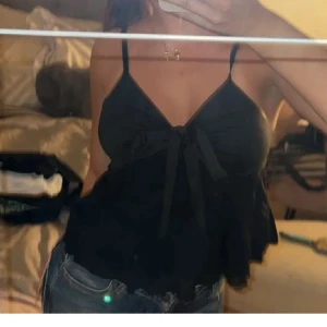 svart topp men rosett - säljer denna oanvända svarta toppen med snören som man kan välja att knyta eller göra en rosett av ❤️ storlek S men passar mig som brukar ha XS/S, materialet är stretchigt 😇