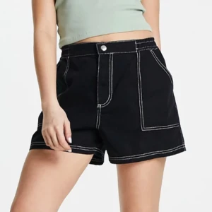 Svarta Cargoshorts ASOS design - Skitsnygga svarta cargoshorts med vita detaljer, ASOS design, i storlek 40. Helt nya, endast testade. Köpta från ASOS. Var lite för stora för mig, men hann inte returnera dem i tid tyvärr. Lånade bilder, men bara att skriva så fixar jag andra bilder.