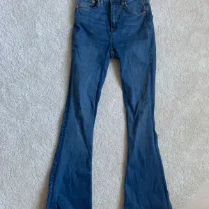 Mörkblåa utsvängda jeans från lager 157 strl xs. Är bara använda 1-2 ggr. (OBS! bilden från hemsidan är samma typ av modell men annan färg!!) midjemått rakt över: 33cm (med stretch) och innerbenslängd: 76 cm