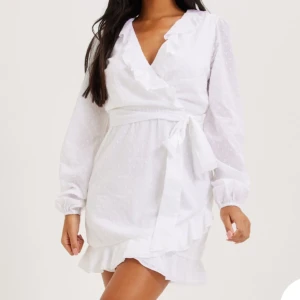 Studentklänning  - Vit kort klänning med volanger, passar perfekt till studenten. Oanvänd med prislapp kvar