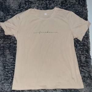 T-shirt i beige med trycket ”Freedom” Oanvänd 1 gång Inget slitage 