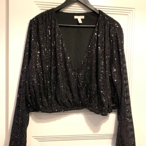 Cropped glitter blouse - Croppad glitterblus från H&M. Använd vid ett tillfälle. Gick upp två storlekar för att få en lösare modell ❤️