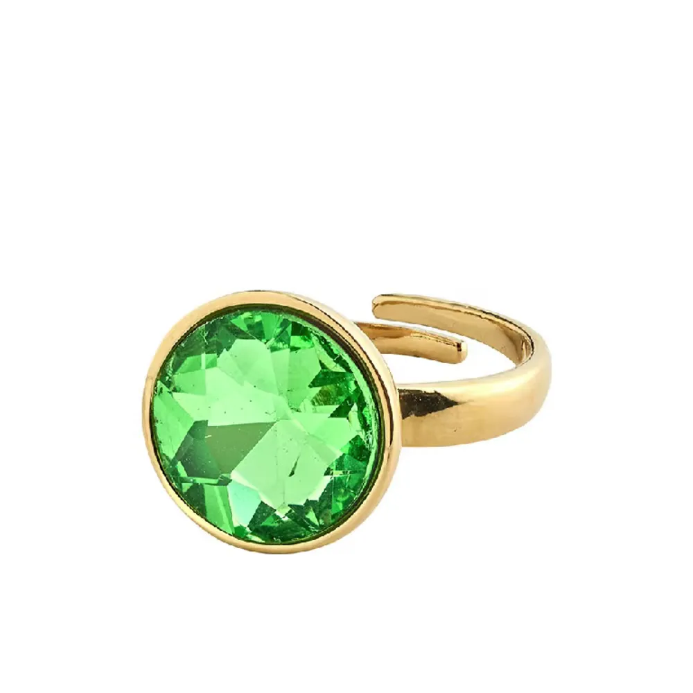 Guldpläterad ring med grön kristall. En symbol för hopp till din smyckessamling. Justerbar storlek med kristall på 15 mm i diameter. 100 % glam piece. Tillverkad av minst 75 % återvunnet material. Nypris är 400kr och den är helt oanvänd!!!. Accessoarer.