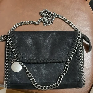 Svart väska  - Säljer en svart väska med siveig kedja , som tyvärr inte kommer till nån användning. 