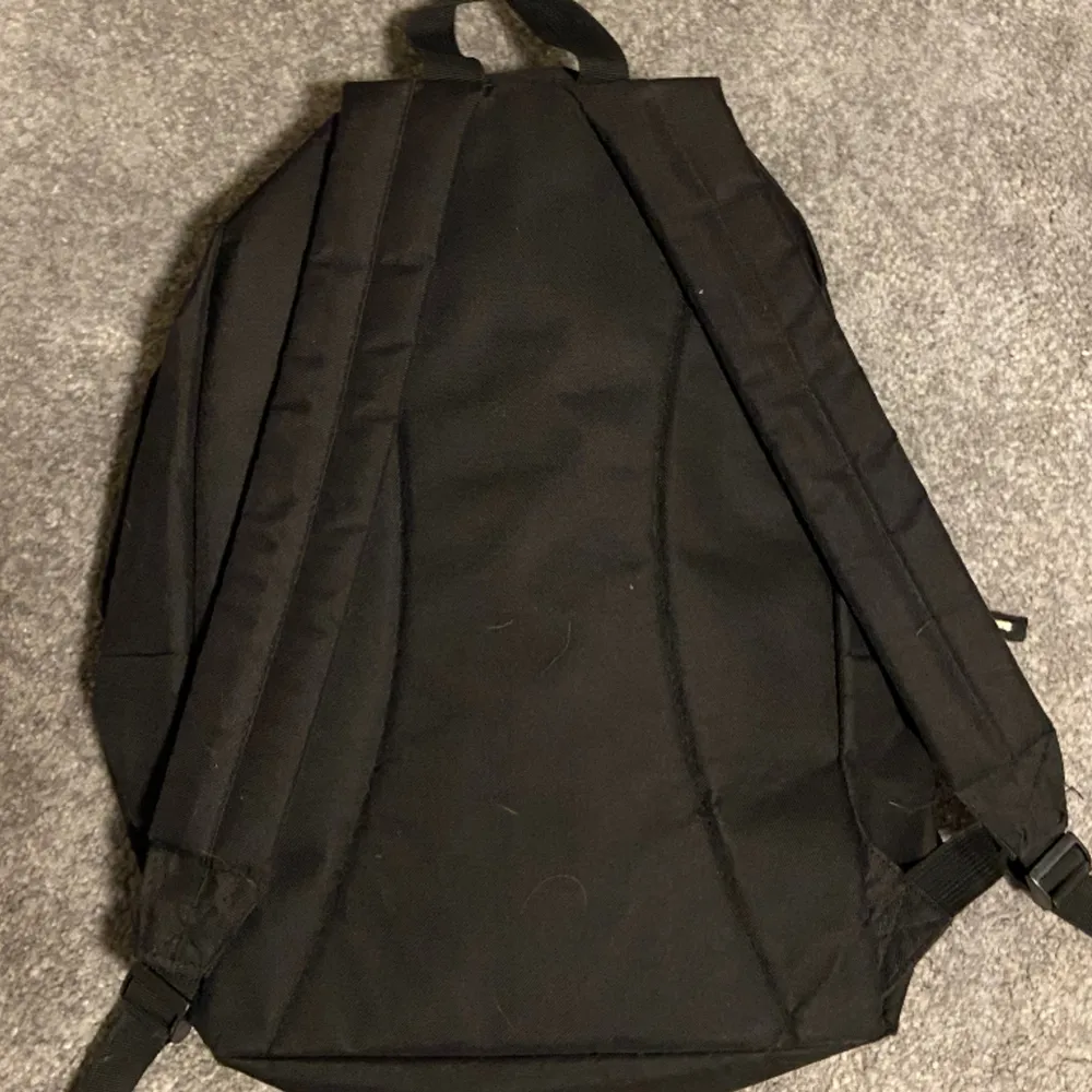 svart ny/new era ryggsäck. använd flertal gånger. inga hål eller problem med dragkedjan.. Väskor.