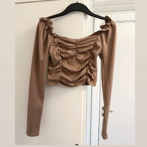 Brun tröja - Super fin brunaktig tröja. Lite ”mönster” överallt. Funkar att ha som både offshoulder men även vanligt. Ganska tunnt material. Säljer likadan i svart. 
