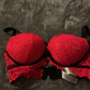 Bh aldrig använd 75B - Röd spets svarta detaljer och en svart rosett där fram  Storlek 75B med push Märke: ensored Aldrig använd