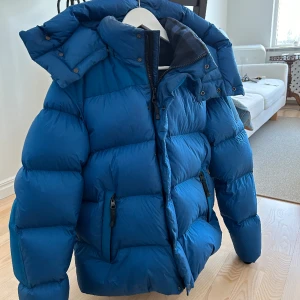 Burberry jacka - Blå Burberry jacka i nyskick.  Säljer för 8000. Nypris 15000. Tjock och varm med bra passform.  Avtagbara ärmar. 