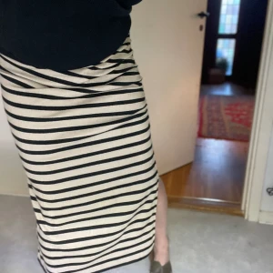 Draperad kjol - Randig halvlång kjol som är draperad på en sidan. Härligt mjukt och stretchigt material. 