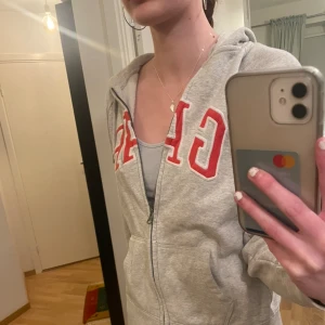 Grå GAP Hoodie - Säljer denna GAP hoodien med rätt tryck i storlek xs, kontakta innan köp!