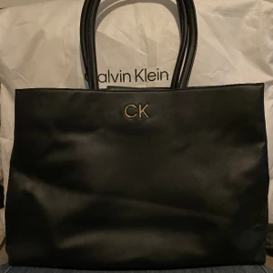 Calvin Klein väska - Calvin Klein väska säljs billigt, köpt för 1700kr i nyckick aldrig använd och kommer med speciell Calvin Klein påse. Säljs för 800kr, pris kan diskuteras, kan avhämtas eller skickas via plocks tjänst.