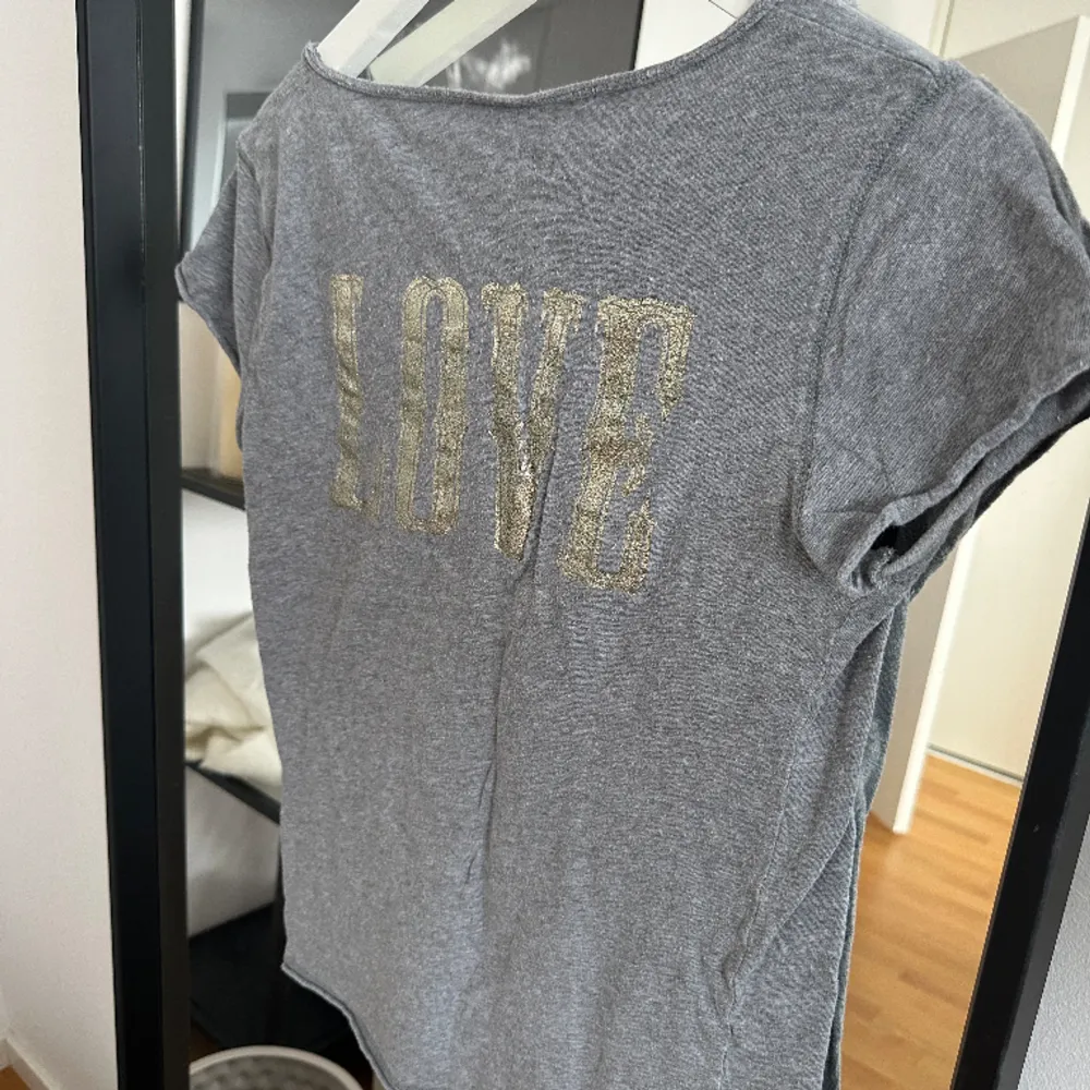 Säljer denna gråa t-shirt från Zadig. Knappt använd! Tryck med glitter på ryggen i ”love”. Storlek: S. T-shirts.