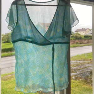 Blommig blus - Jätte söt turkos blommig blus i storlek M/L Rekommenderar inte till nån med större byst för bhn kommer sticka fram och den sitter ganska så tajt runt bysten, önska den fortfarande passa mig men tyvärr inte på samma sätt längre 