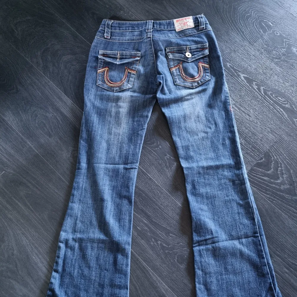 True religion jeans i snygg sliten blåfärg. Joey low flare. Stl 28.   Midjemått rakt över är 36 cm. Innerbenlängd 80 cm.  En knapp på bakfickan saknas tyvärr.  . Jeans & Byxor.