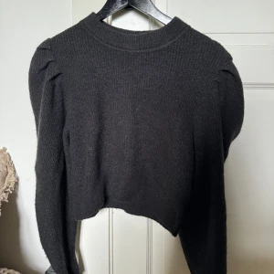 Stickad tröja - En stickad tröja med puffiga armar. Super fin tröja som är i mycket bra skick. Inga defekter. Den är lite svart grå. Skriv om ni har frågor eller vill diskutera pris🩷
