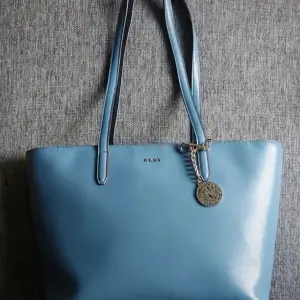 Väska DKNY, Mycket bra stick som ny. Gråblå färg. Mycket rymlig, passar bra för A4-format. 