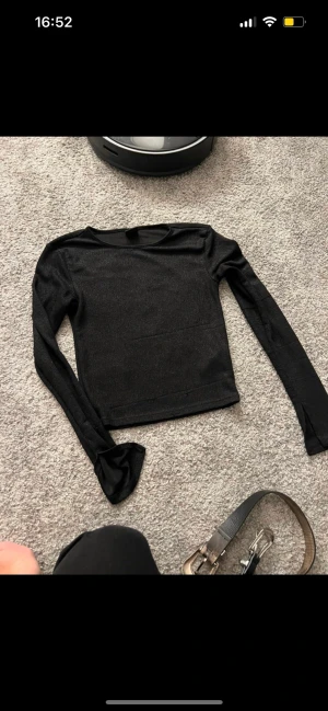 Tröja med utsvängda ärmar - Slits i ärmen och glitter i tyget. Har lite slitningar på ärmarna (se bild)