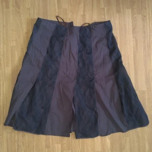 En kjol med spets och slits från Day Birger et Mikkelsen  - En vintage märkeskjol i purpur och spets ränder i 100% nylon. Jag är 166 cm lång och den går mig till runt 3 cm under knäna.