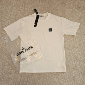 Stone Island T-shirt M/L - Få den perfekta kombinationen av stil och komfort med denna oversized T-shirt! Märkt som M, men känns som L, med högkvalitativt tyg och replikadesign för den perfekta streetwear-looken.