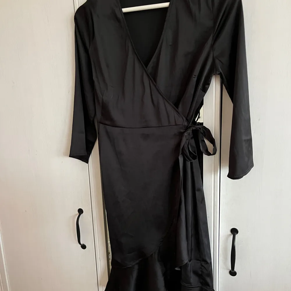 En svart klänning med volanger nedtill samt knytning i midjan från Vero Moda i strl XS!💓. Klänningar.
