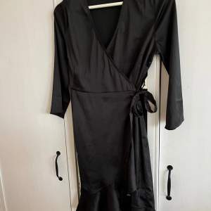 En svart klänning med volanger nedtill samt knytning i midjan från Vero Moda i strl XS!💓