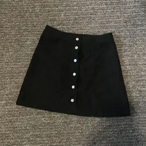 Fin svart kjol med knappar på i storlek 38 aldrig använd 