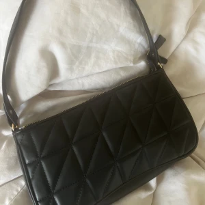 Handväska  - Svart handväska med axelband som kommer med, aldrig använd 