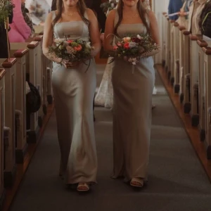 Långklänning - En grön långklänning som passar bra för balen eller på bröllop. Varan är endast använd en gång, som en tärnklänning på ett bröllop. Bild tre visar hur klänningen ser ut på baksidan. Originalpriset var 1569kr!