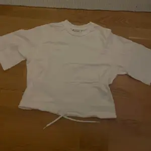 en croppad t-shirt från monki. tröjan har ett snöre som använda för att knyta tröjan. nästan helt oanvänd förutom på en skolavslutning. storlek XS, men kan även passa någon med S. om ni har några frågor får ni gärna höra av er! :)