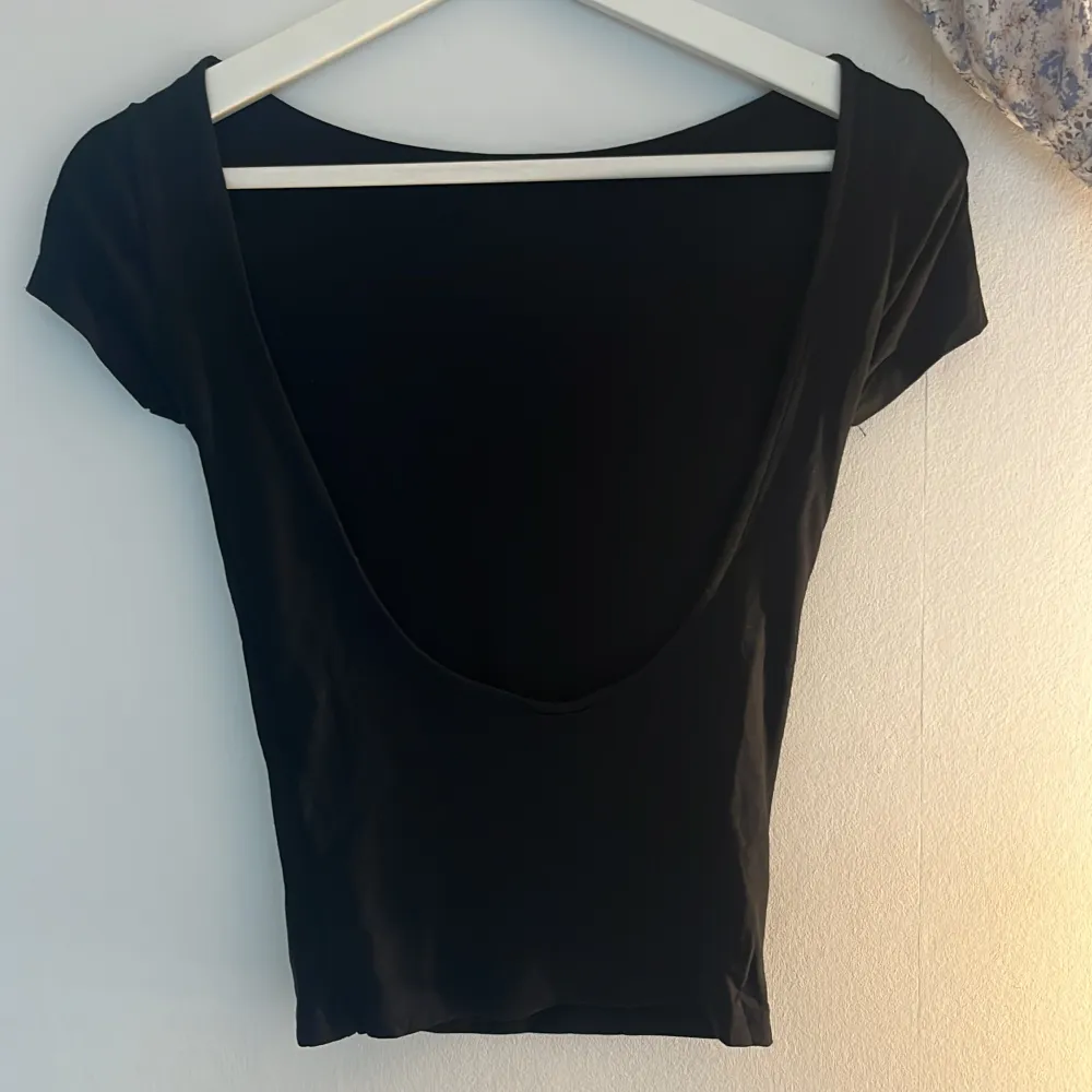T-shirt med öppen rygg från Gina Tricot. Aldrig använd och nypris är 200kr.. T-shirts.