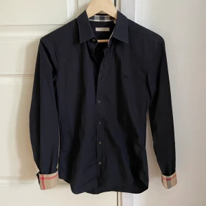Burberry skjorta - En riktigt snygg burberry skjorta! Skicket är väldigt bra. Nypris omkring 6000kr, mitt pris endast 1095kr! Hör av er vid funderingar.