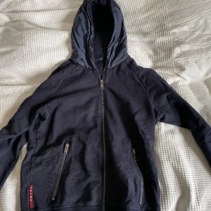 Prada hybridjacka  - Riktigt fin Prada hybridjacka/kofta. Passar storlek M ( även S). Äkta såklart. Skick 9/10 inga flaws alls på plagget😀Först till kvarn!!
